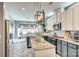 Open kitchen boasts stainless steel appliances, white cabinets, and a herringbone floor pattern at 249 Sand Paver Way, Fort Mill, SC 29708