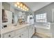 Bright bathroom with double vanity sinks, large mirror, soaking tub, and natural light at 249 Sand Paver Way, Fort Mill, SC 29708