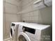 Laundry room with front load Samsung washer and dryer and white shelving at 300 S Main St # K, Salisbury, NC 28144