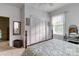 Bedroom with white paneled walls, a wooden bed frame, and two bright windows at 306 W Marsh St, Salisbury, NC 28144