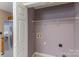 Bright laundry room with tile flooring, washer/dryer hookups, and wire shelving for organized storage at 3230 Richway Ct, Charlotte, NC 28216
