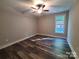 Neutral toned bedroom is complete with hardwood floors, ceiling fan, and bright window views at 404 Imperial Way, Albemarle, NC 28001