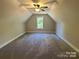 A spacious bonus room featuring an angled ceiling, ceiling fan, and neutral carpeted flooring at 404 Imperial Way, Albemarle, NC 28001