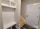 Mudroom with built-in storage cubbies and a bench, plus a nearby staircase and exterior door at 404 Imperial Way, Albemarle, NC 28001