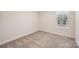 Cozy bedroom featuring neutral walls, plush carpeting, and a bright window at 4548 Millennium Ave, Charlotte, NC 28217