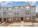 Attractive townhome showcasing a gray exterior with red brick accents and a well-manicured front yard at 4548 Millennium Ave, Charlotte, NC 28217