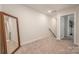 Bright room with a large mirror, carpet, and a view of the hallway with stairs at 4548 Millennium Ave, Charlotte, NC 28217