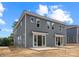 Rear view of a gray two-story townhouse with sliding glass doors and small concrete patios at 507 Bowman Rd, Charlotte, NC 28217