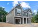 Two-story gray townhouse showcasing the attached garage and covered entryway with white pillars at 507 Bowman Rd, Charlotte, NC 28217