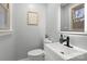 Updated half bathroom with modern fixtures and a sleek, illuminated mirror at 512 Rhodes Ave, Kings Mountain, NC 28086