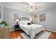 Bright bedroom featuring hardwood floors, two large windows, neutral color palette, and modern ceiling fan at 512 Rhodes Ave, Kings Mountain, NC 28086