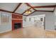 Open living room with wood floors, brick fireplace, wood beam ceiling and open to the bright kitchen at 512 Rhodes Ave, Kings Mountain, NC 28086