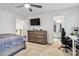Bright bedroom featuring carpet floors, a ceiling fan, TV, and walk-in closet with organized storage at 531 Red Wolf Ln, Clover, SC 29710