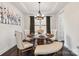 Beautiful dining room features a round table, tufted chairs, bench, and tray ceiling with a modern chandelier at 531 Red Wolf Ln, Clover, SC 29710