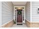 View of the front door with a dark finish, a wreath, sidelights and brick accents at 531 Red Wolf Ln, Clover, SC 29710