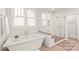 A modern bathroom with a soaking tub, glass-enclosed shower with herringbone tile, and natural light at 5717 Closeburn Rd, Charlotte, NC 28210