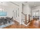 Bright hallway with hardwood floors, stairs, and a glimpse into the living room at 5717 Closeburn Rd, Charlotte, NC 28210