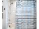 A shower with white tiled walls, a shower curtain, and updated fixtures at 621 Bristol Dr, Statesville, NC 28677