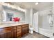 Bright bathroom featuring a double vanity and a shower with white tile and gray wood flooring at 634 Gants Rd, York, SC 29745