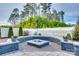 Backyard fire pit area surrounded by slate and paved patio with landscaped flower beds and mature trees at 634 Gants Rd, York, SC 29745