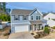 Charming two-story home featuring a well-maintained lawn, attached garage, and inviting front porch seating area at 634 Gants Rd, York, SC 29745