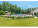 Community pool featuring a water slide and splash pad surrounded by mature trees and green space at 8418 Loxton Cir, Charlotte, NC 28214