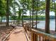 Wooden boardwalk leading to a private boat dock on a serene lake, surrounded by lush trees at 8418 Loxton Cir, Charlotte, NC 28214