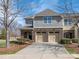 Charming townhouse exterior features brick and gray shingle facade, complemented by a two-car garage and a spacious driveway at 8418 Loxton Cir, Charlotte, NC 28214