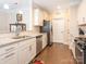 Galley kitchen featuring stainless steel appliances, granite countertops, white cabinets, and a stylish subway tile backsplash at 8418 Loxton Cir, Charlotte, NC 28214