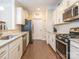 Modern kitchen features stainless steel appliances, white cabinetry, granite countertops, and hardwood floors at 8418 Loxton Cir, Charlotte, NC 28214