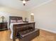 Main bedroom featuring hardwood floors, a ceiling fan, a queen bed and matching wood furniture at 8418 Loxton Cir, Charlotte, NC 28214