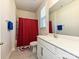 A bathroom features a single sink vanity, toilet, and shower with a red shower curtain at 9432 Liberty Hill Dr, Mint Hill, NC 28227