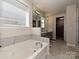 Bright bathroom with marble tile surround soaker tub, a double sink vanity, and separate shower at 9432 Liberty Hill Dr, Mint Hill, NC 28227