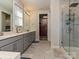 The bathroom boasts a modern design with a double sink vanity, walk-in shower, and access to a walk-in closet at 9432 Liberty Hill Dr, Mint Hill, NC 28227