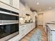 Bright kitchen features white cabinets, stainless steel appliances, granite countertops, and wood-look flooring at 9432 Liberty Hill Dr, Mint Hill, NC 28227
