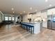 Open-concept kitchen featuring a large island with seating, stainless steel appliances, and hardwood floors at 9432 Liberty Hill Dr, Mint Hill, NC 28227