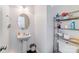 Efficient half bathroom with pedestal sink and decorative shelving for storage at 10316 Stineway Ct, Pineville, NC 28134