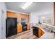 Functional kitchen with wood cabinets and black appliances, open to the living area at 10316 Stineway Ct, Pineville, NC 28134