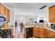 Well-lit kitchen with wood cabinets, stainless sink and open view to the living room at 10316 Stineway Ct, Pineville, NC 28134