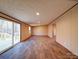 Open-concept living room featuring new laminate floors and sliding glass doors at 1085 Cedar Hill Dr, Rockwell, NC 28138