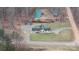 Aerial view of a home featuring a well-maintained yard, surrounded by trees, with driveway and additional outbuilding at 201 Indian Hill Rd, Union Grove, NC 28689