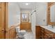 Bathroom featuring a wood vanity, white toilet, glass enclosed shower, and a window at 201 Indian Hill Rd, Union Grove, NC 28689
