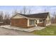 View of the back exterior with brick accents, access to a back porch, and concrete ground cover at 201 Indian Hill Rd, Union Grove, NC 28689