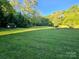 A sprawling backyard featuring mature trees offering shade, and a well-maintained lawn at 202 Oakwood St, Stanfield, NC 28163