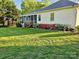 Back exterior view showcasing the screened-in porch with colorful landscaping at 202 Oakwood St, Stanfield, NC 28163