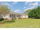 Back exterior view showcasing the screened-in porch with lush landscaping at 202 Oakwood St, Stanfield, NC 28163