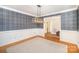 Elegant dining room with plaid wallpaper, wooden floors, carpet, and decorative light fixture at 202 Oakwood St, Stanfield, NC 28163