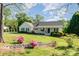 Inviting single-story home with a front porch, landscaped garden, and lush lawn at 202 Oakwood St, Stanfield, NC 28163