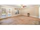 Bright living room featuring a ceiling fan, natural light, and a door to an outdoor area at 202 Oakwood St, Stanfield, NC 28163