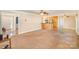 Spacious living room with neutral walls and large windows, flowing into the kitchen area at 202 Oakwood St, Stanfield, NC 28163